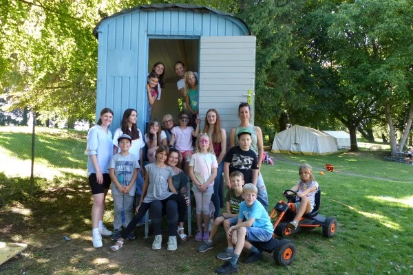 Das Bild zeigt Kinder vor einem Wohnwagen