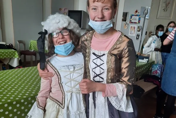 Das Bild zeigt zwei Kinder in antiken Kostümen