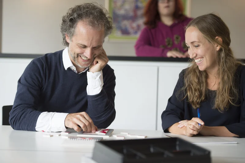 Das Bild zeigt einen Mann und eine Frau die zusammen sitzen und gemeinsam arbeiten