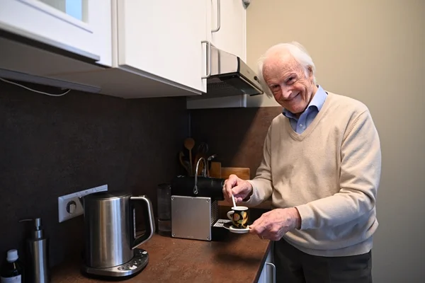 Service-Wohnen Tettnang Das Bild zeigt einen Mann in einer Küche beim Kaffee kochen