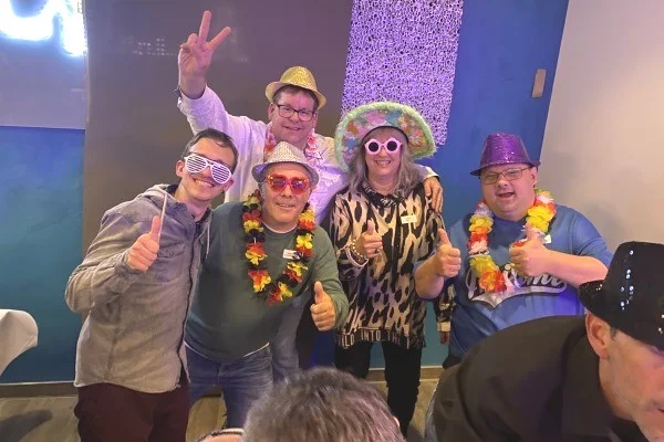 Ein bewegtes Vierteljahrhundert - 25 Jahre Liebenau Service Das Bild zeigt 4 Personen in Feierstimmung auf einer Bühne
