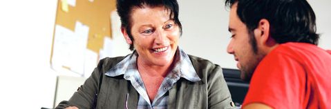 Das Bild zeigt eine Frau und einen Mann an einem Tisch im Gespräch