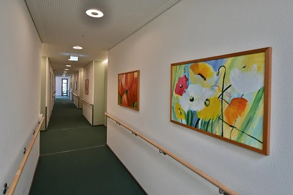 Das Bild zeigt einen Flur mit Bildern