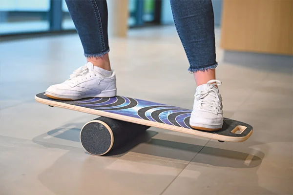 Balanceakt Die Beine einer Person auf einem Balanceboard