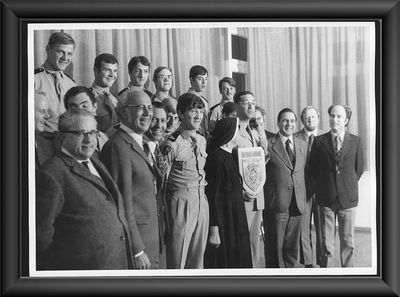 1974, Französische Soldaten in Rosenharz. Eine Einheit von zwölf Mann des französischen 11. Pionierregiments trifft mit schweren Baumaschinen am Standort Rosenharz ein. Die Stiftung Liebenau hatte sich auf der Suche nach Unterstützung an die in Rastatt stationierten französischen Streitkräfte gewandt. Neben einer Werkstatt soll ein Sportplatz für Menschen mit Behinderung errichtet werden. Vier Wochen benötigen die Soldaten, um alle Planierarbeiten abzuschließen. Als Dank für die Unterstützung erhalten die Soldaten Geschenke, die von den Jungen und Mädchen der Berufsvorbereitung hergestellt wurden. Das Bild zeigt die Überreichung des Logos von Direktor Norbert Huber an Kompaniechef Capitaine Brousse.