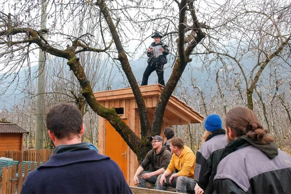 Auslandspraktikum Das Foto zeigt einen angehenden Zimmerer auf dem Dach beim Richtspruch.