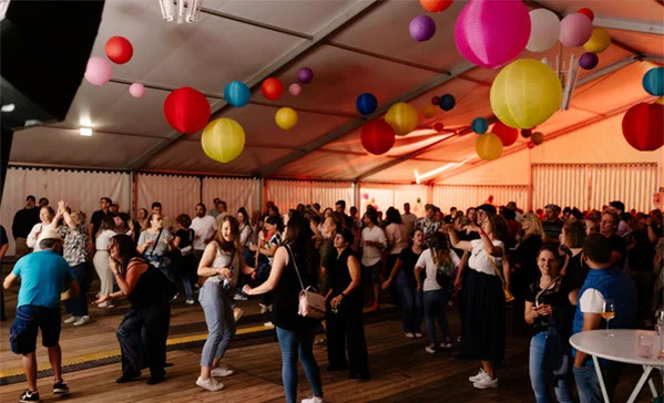 das bild zeigt viele tanzende mitarbeitende in einem zelt auf dem mitarbeiter-fest der stiftung-liebenau