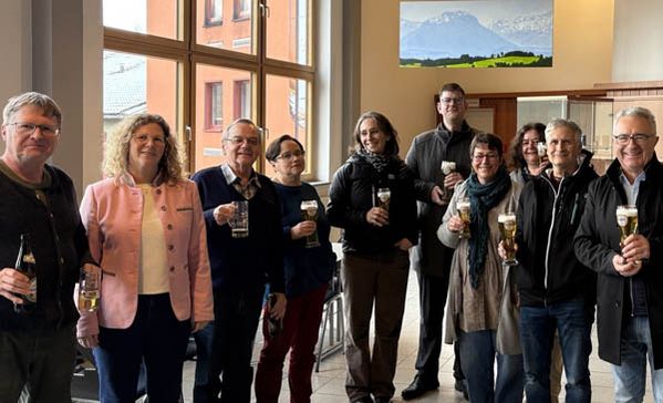 Eine Gruppenbild mit 10 Personen mit Gläsern in der Hand.