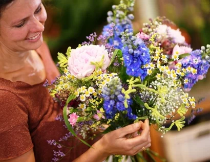 Das Bild zeigt eine junge Frau mit einem Blumenstrauß