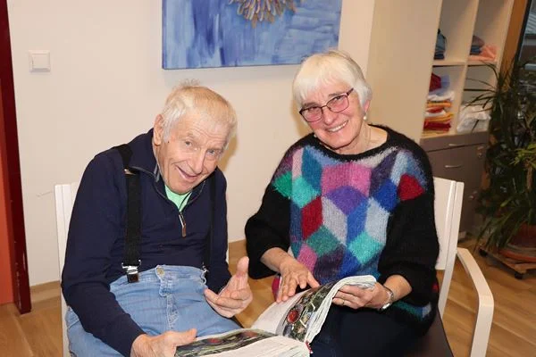 Gemeinsam mit einem Patienten guckt Hilde Wilske ein Buch an. Gemeinsam mit einem Patienten guckt Hilde Wilske ein Buch an.
