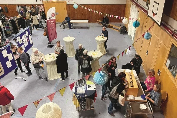 Das Bild zeigt mehrere Personen die gemeinsam in einem Festsaal stehen