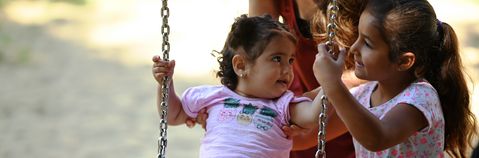  Das Bild zeigt zwei Kinder auf einer Schaukel