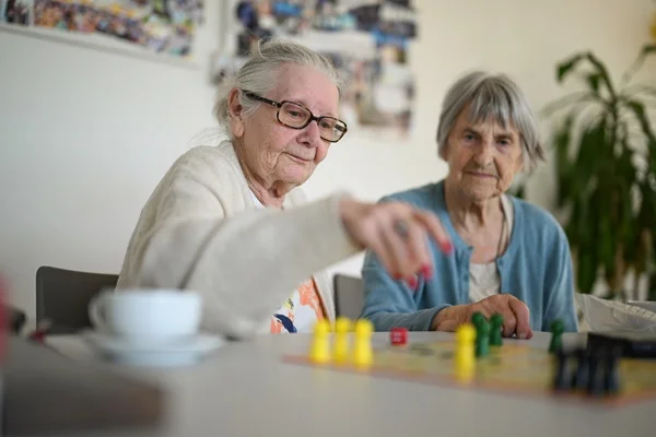 Das Bild zeigt zwei Frauen beim Mensch-Ärgere-Dich-nicht-Spiel