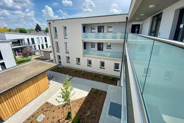 Das Bild zeigt den Blick von einem Balkon in einen Hof