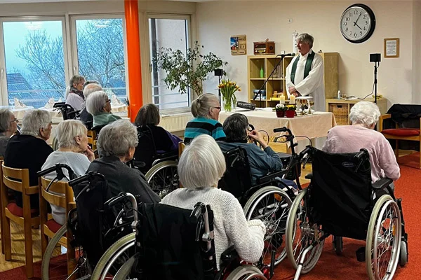 Gottesdienst zum Namenstag Das Foto zeigt den Pfarrer Reinhold Hübschle und die Besucher des Gottesdiensts.