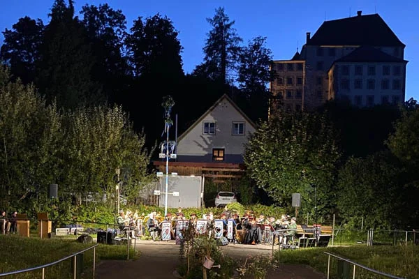 Musikkapelle sitzend draußen vor einem Gebäude