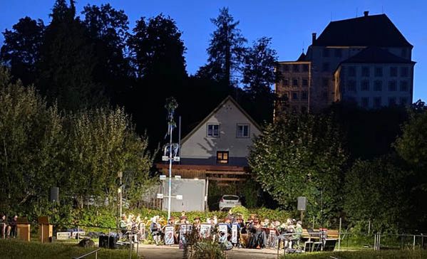 Musikkapelle sitzend draußen vor einem Gebäude