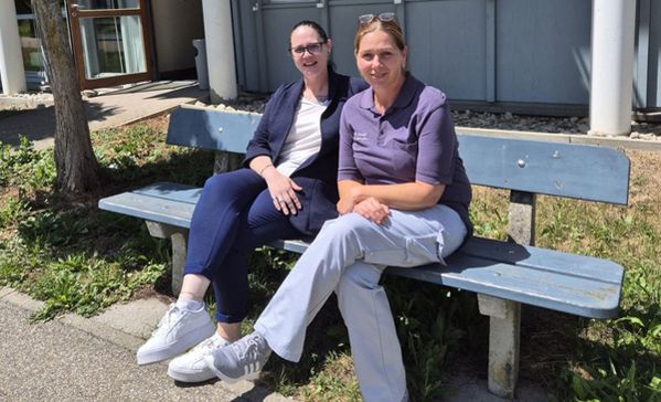 zwei flexteam-mitarbeiterinnen aus der pflege sitzen auf einer bank