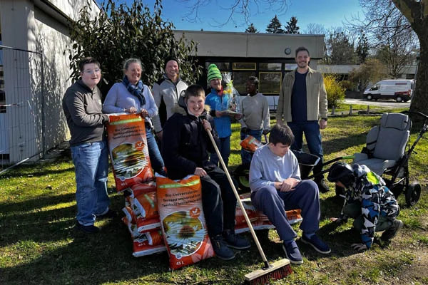 Erdspende für neue Lernerfahrungen Das Foto zeigt die Schülerinnen und Schüler und Andreas Geschwind, Gärtnermeister bei Ökohum.