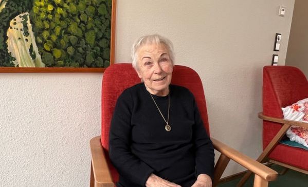 Eine ältere Dame lächelt in die Kamera