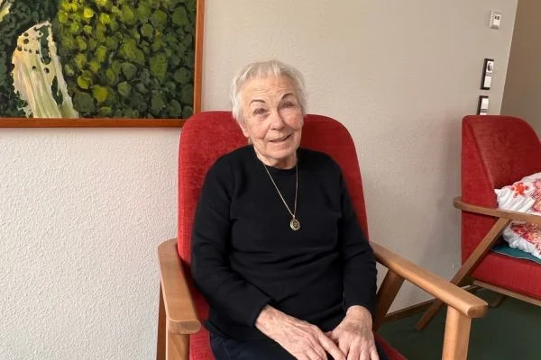 Eine ältere Dame lächelt in die Kamera