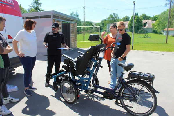 Rollstuhlfahrrad Das Foto zeigt das neue Rollstuhlfahrrad und einige Personen.