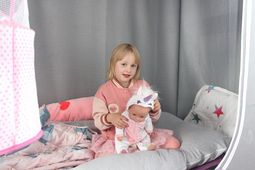 Das Foto zeigt ein Kind mit einer Puppe.