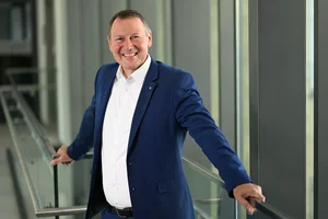 Dr. Berthold Broll Das Bild zeigt Dr. Berthold Broll der an einem durchsichtigen Geländer lehnt