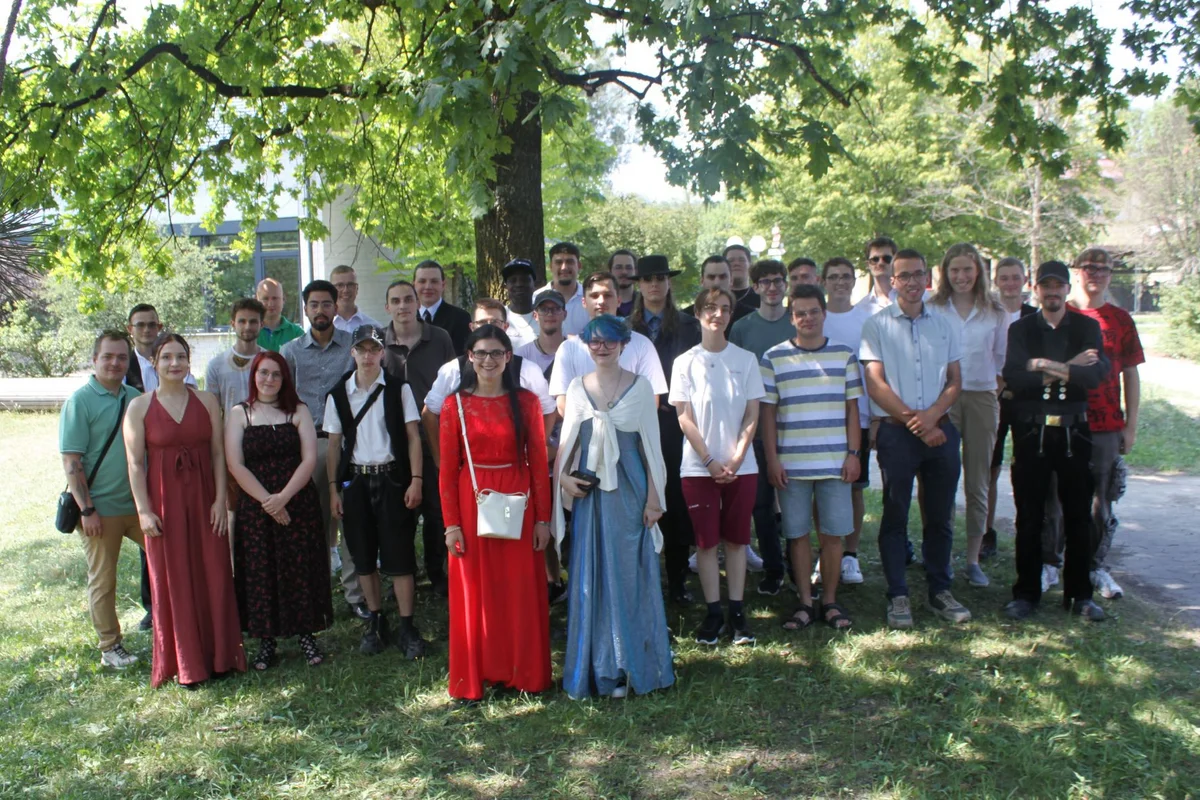 Absolventenfeier Gruppenbild vieler Menschen auf einer Wiese