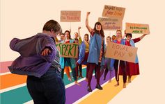 Eine Person im Vordergrund hat die Arme ausgestreckt und eine Personengruppe hebt Schilder in die Höhe.