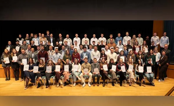 Ein Gruppenbild mit sehr vielen Personen mit Zeugnissen in der Hand.