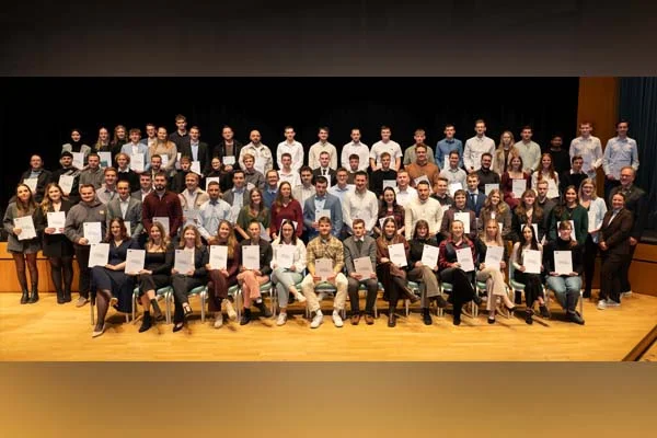 Ein Gruppenbild mit sehr vielen Personen mit Zeugnissen in der Hand.