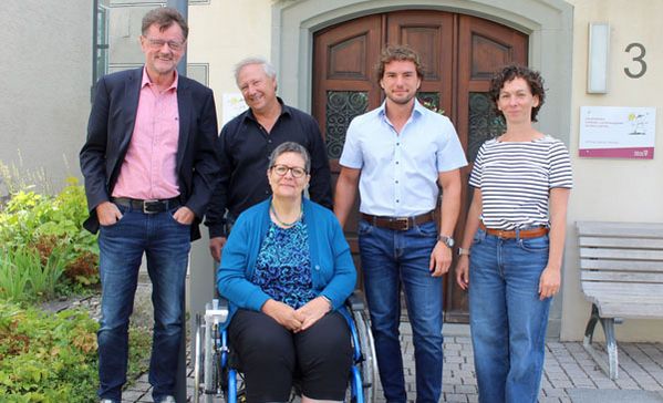 das bild zeigt eine gruppe von mitarbeitenden der frühförderstelle. eine frau sitzt im rollstuhl.