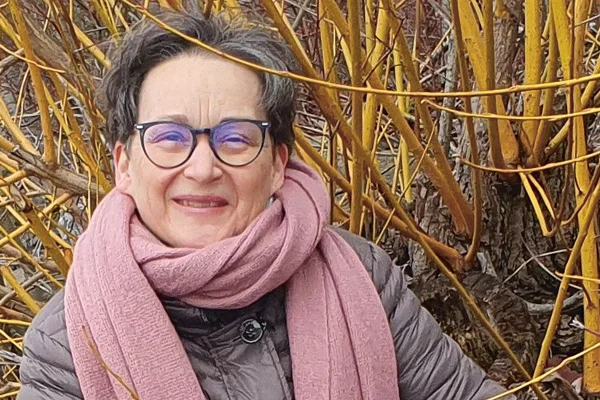 Ein Portraitfoto einer Frau, die in die Kamera lächelt.
