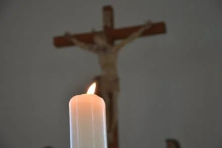 Seelsorge Das Bild zeigt eine Kerze die vor brennt einem Kreuz