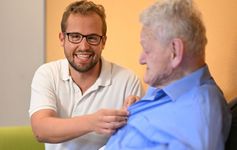 Zwei Männer sitzen auf einem Sofa.