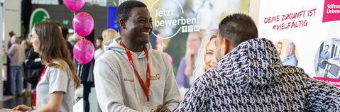 Zwei Männer unterhalten sich auf einer Messe.