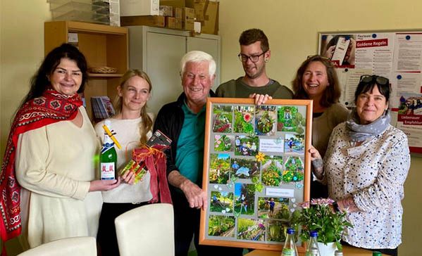 Das Foto zeigt Magnus Rauh mit dem Geschenk und weitere Personen.