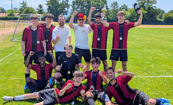 Fußballmeisterschaft Eine Fußballmannschaft beim Gruppenfoto jubelt.