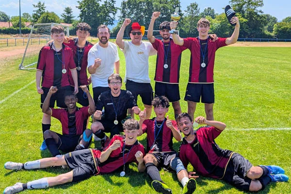 Eine Fußballmannschaft beim Gruppenfoto jubelt.