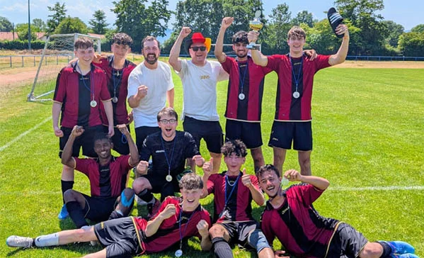 Fußballmeisterschaft Eine Fußballmannschaft beim Gruppenfoto jubelt.