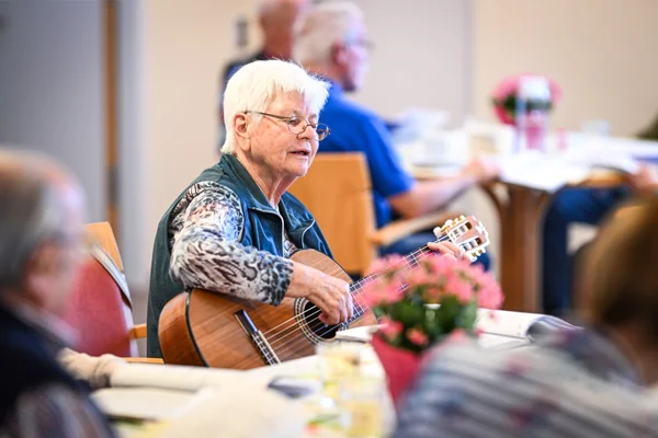 Eine Frau spielt Gitarre beim Betreuungsangebot im Haus der Pflege St. Gebhard 