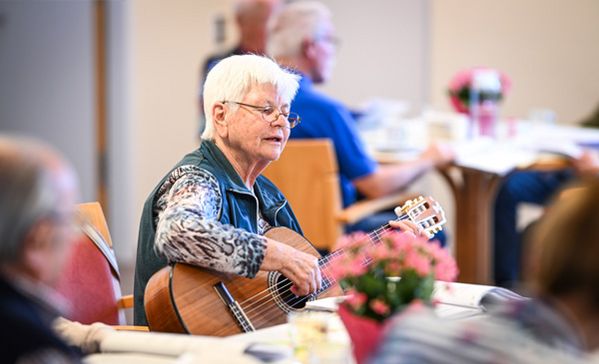 Eine Frau spielt Gitarre beim Betreuungsangebot im Haus der Pflege St. Gebhard 