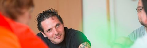 Das Bild zeigt mehrere junge Männer an einem Tisch
