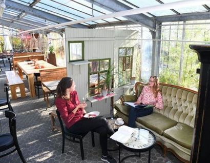 Das Bild zeigt zwei Personen an einem Tisch im Glashauscafe