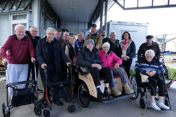 Das Foto zeigt die Rikscha mit Verantwortlichen vom Rotary Club, die Bewohnerschaft sowie Verantwortliche des Haus der Pflege. 