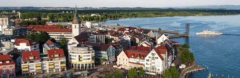Das Bild zeigt eine Drohnenaufnahme von Friedrichshafen und dem Bodensee