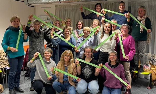 Eine Menschengruppe lacht in die Kamera