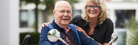 Das Bild zeigt einen älteren Mann auf einem Motorrad und eine Frau