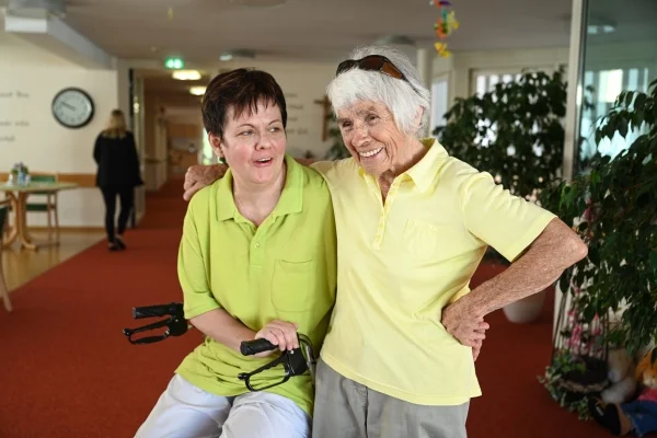 Das Bild zeigt eine Pflegerin mit einer älteren Dame